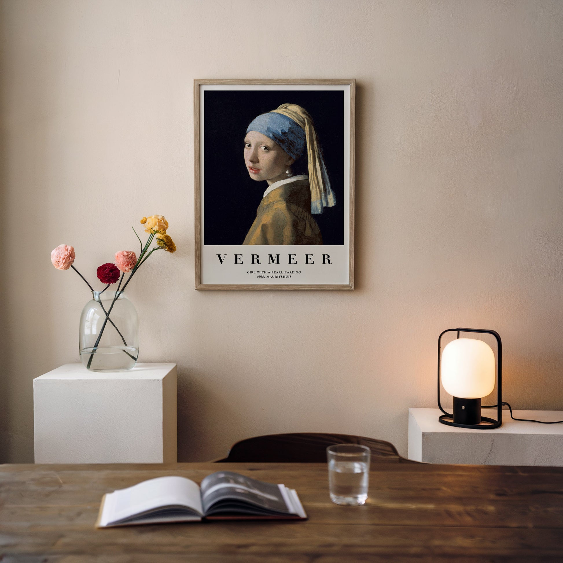 Art print of Vermeer's "Girl with a Pearl Earring," featuring a young woman with a blue and gold headscarf and a pearl earring, set against a dark background.