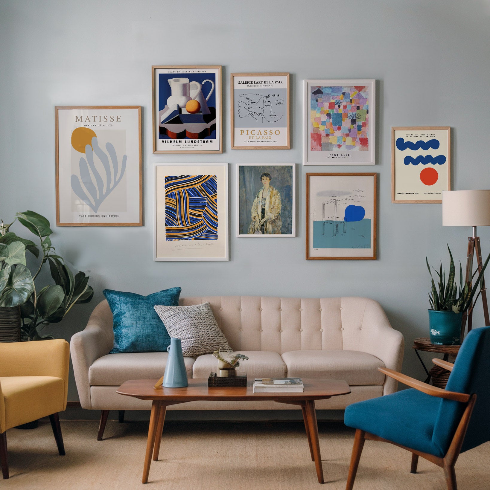 Set of eight modernist art prints featuring works by Matisse, Picasso, and Klee, arranged on a light blue wall in a mid-century modern living room, combining abstract and figurative styles for a dynamic gallery wall display.